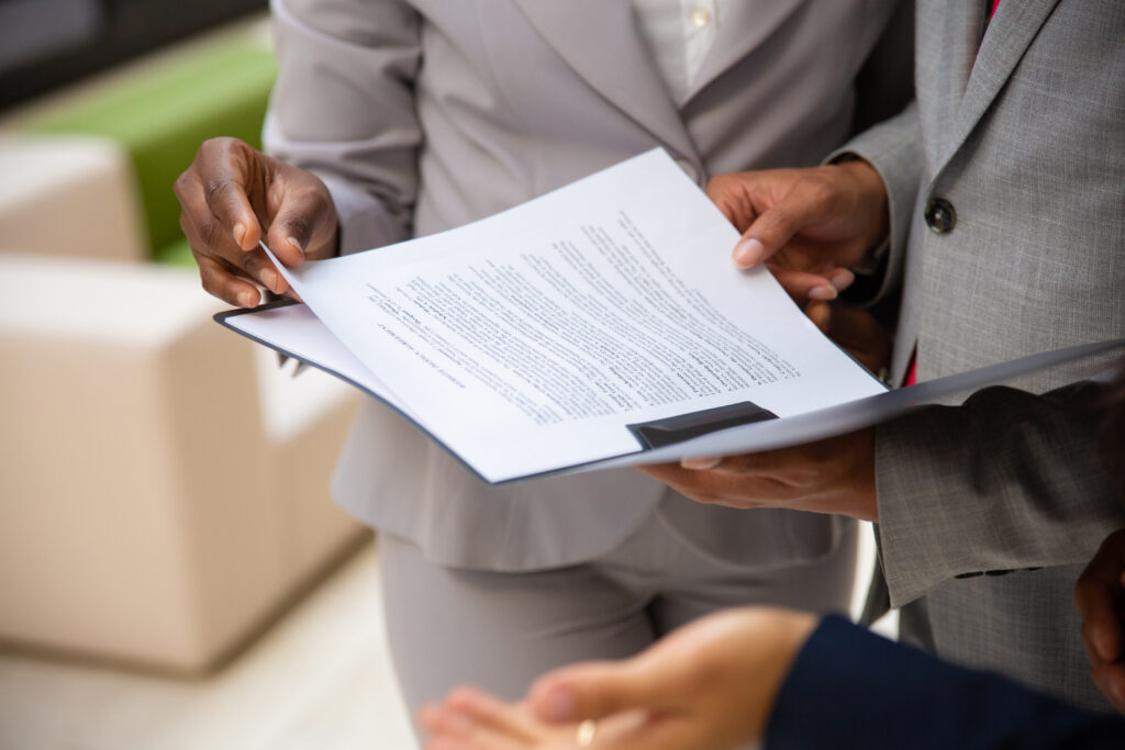 diverse business partners reading contract together